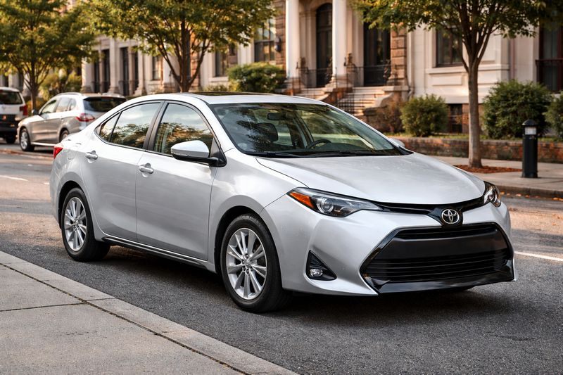 Used Toyota Corolla front-wheel-drive sedan parked on a city street, ideal for budget buyers.
