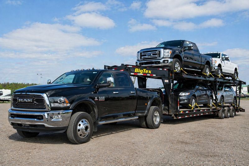 Heavy-duty pickup truck with gooseneck trailer transporting multiple cars